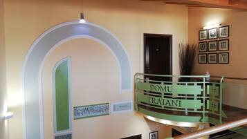 Una escalera con barandilla verde y un letrero que dice "DOMUS TRAIANI".