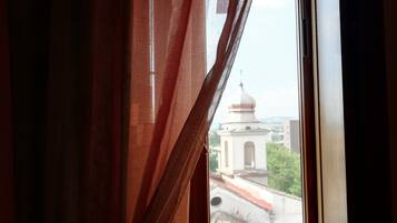 Ein Fenster mit Blick auf ein Gebäude mit Kuppel und roten Ziegeldach.