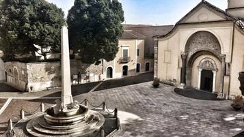 A courtyard with a central monument, surrounded by buildings with classical architecture.