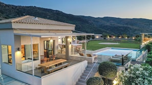 A modern house with a pool, outdoor seating, and a view of the hills. - Villa Kedria with a panoramic ocean view (Chania)