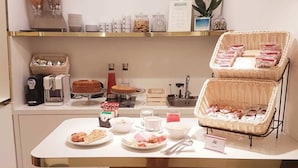 A breakfast buffet setup with various food items, a coffee machine, and wicker baskets. - Little Queen Pantheon Residence (Rome)