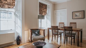 Un coin repas avec une table et des chaises en bois, un vase et une lampe.