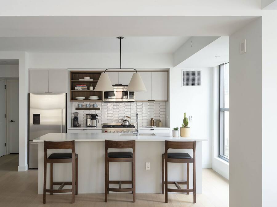 A modern kitchen with a central island, pendant lighting, and built-in appliances.