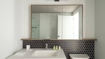 Ein Badezimmer mit weißem Waschbecken, Spiegel und Toilette.