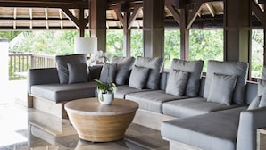 A modern lounge area with a sofa set, a round coffee table, and a potted plant. - REVĪVŌ Wellness Resort Nusa Dua Bali (Nusa Dua)