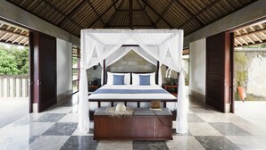 A spacious bedroom with a large bed, a wooden bench, and a canopy bed. - REVĪVŌ Wellness Resort Nusa Dua Bali (Nusa Dua)