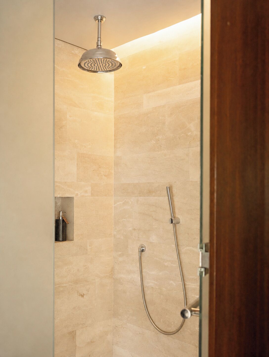 Ducha con cabezal de ducha de mano y grifo de pared.