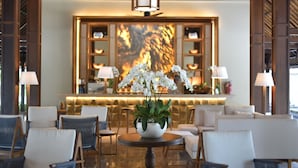 A lobby with a reception desk, seating area, and a decorative plant centerpiece. - REVĪVŌ Wellness Resort Nusa Dua Bali (Nusa Dua)