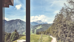 A mountain landscape with a dirt road and a wooden structure.