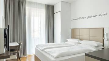 Una habitación de hotel con una cama, un escritorio y una silla.