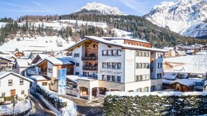 Hotel Sport con diseño moderno, ubicado en una zona montañosa nevada y vistas a picos cubiertos de nieve.