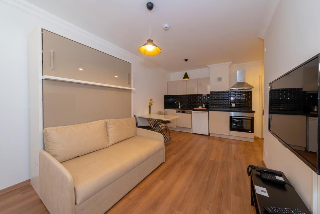 Un espace de vie compact comprenant un canapé, une kitchenette et un coin repas.