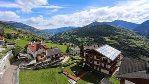 A residential area with houses, a clear sky, and mountains in the background. - Hotel Haus an der Luck (Barbiano)