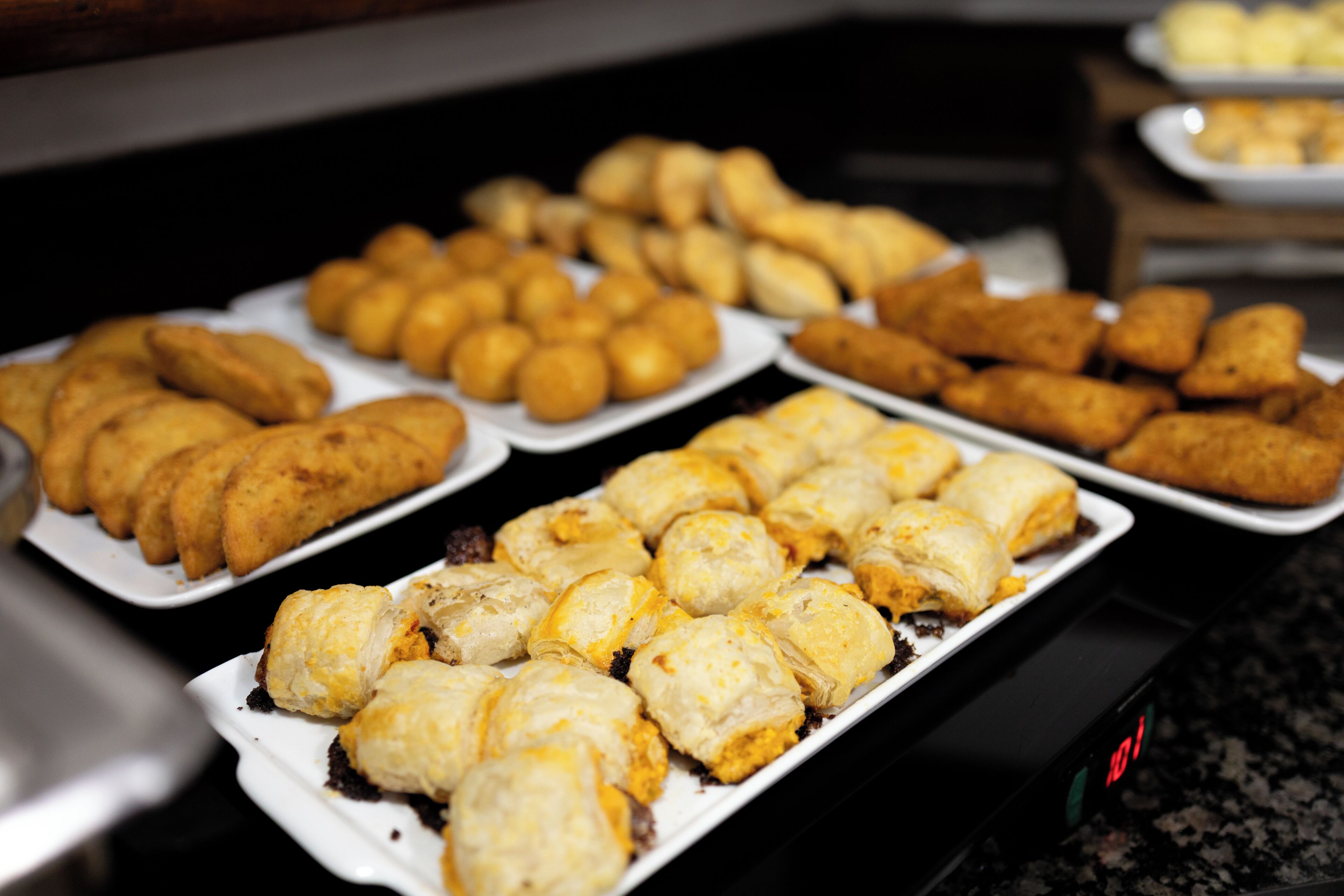 A buffet with various food items including pastries and fried foods.