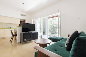 Departamento Deluxe, 1 habitación | Área de sala de estar | Televisión de pantalla plana 
