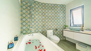 A bathroom with a bathtub, toilet, and sink.