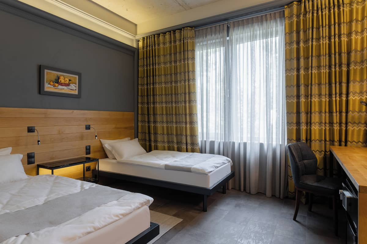 Habitación de hotel con dos camas, un escritorio y una silla.
