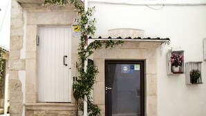 A building entrance with a white door, a small window with flowers, and a sign indicating a 9.4 rating. - L'Angolo di Gaudì (Putignano)