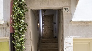 A narrow stone staircase leading to a door marked with the number 75. - L'Angolo di Gaudì (Putignano)