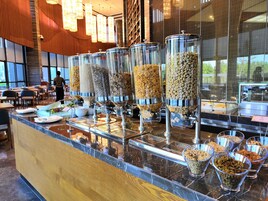 Un área de bufé con varios dispensadores de alimentos y tazones de diferentes granos y nueces.