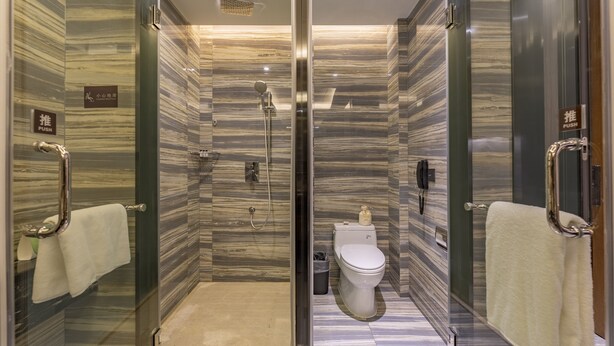Un baño moderno con ducha acristalada, inodoro y bidé.