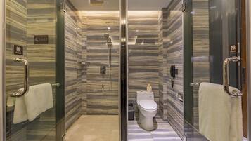A modern bathroom with a glass-enclosed shower, a toilet, and a bidet.