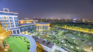 A modern hotel with a rooftop garden, a circular building, and a view of the city skyline at night. - Jinling Grand Hotel Nanchang (Nanchang)