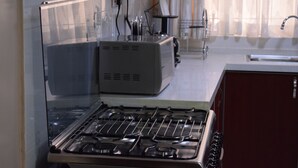 Een keuken met een fornuis, een koelkast en een spoelbak.