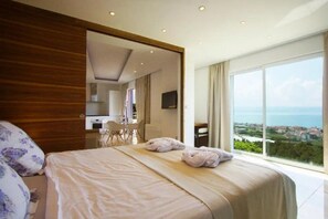 A modern hotel room with a large bed, a desk, and a view of the sea. - Belvedere Apartments (Podstrana)