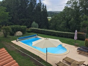 Una piscina al aire libre de temporada, sombrillas