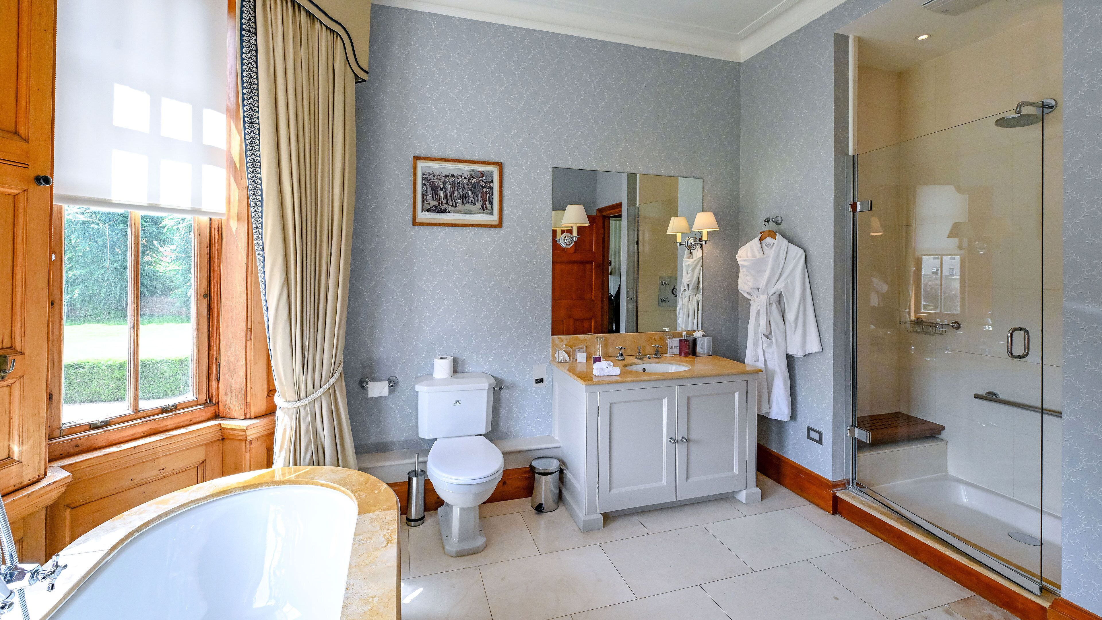 A bathroom with a bathtub, toilet, sink, and shower.