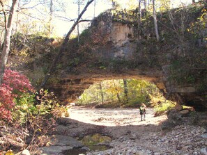 A natural rock formation with a person standing under it.