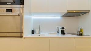 A modern kitchen with a Bosch oven, a sink, and a coffee machine. - The Rossio Studio (Lisboa ciudad)