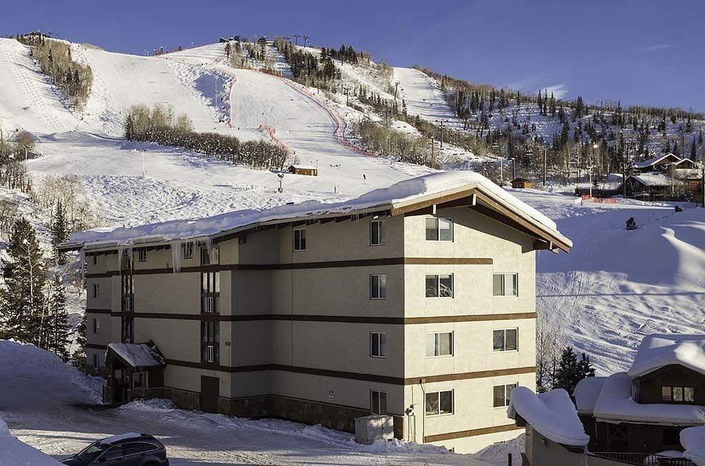 Ein mehrstöckiges Hotel mit flachem Dach in einer verschneiten Berglandschaft.