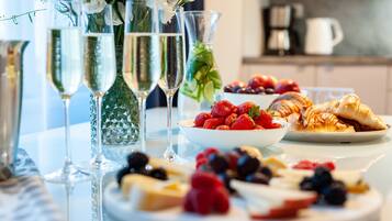 A table with champagne flutes, a bowl of strawberries, and a plate of pastries.