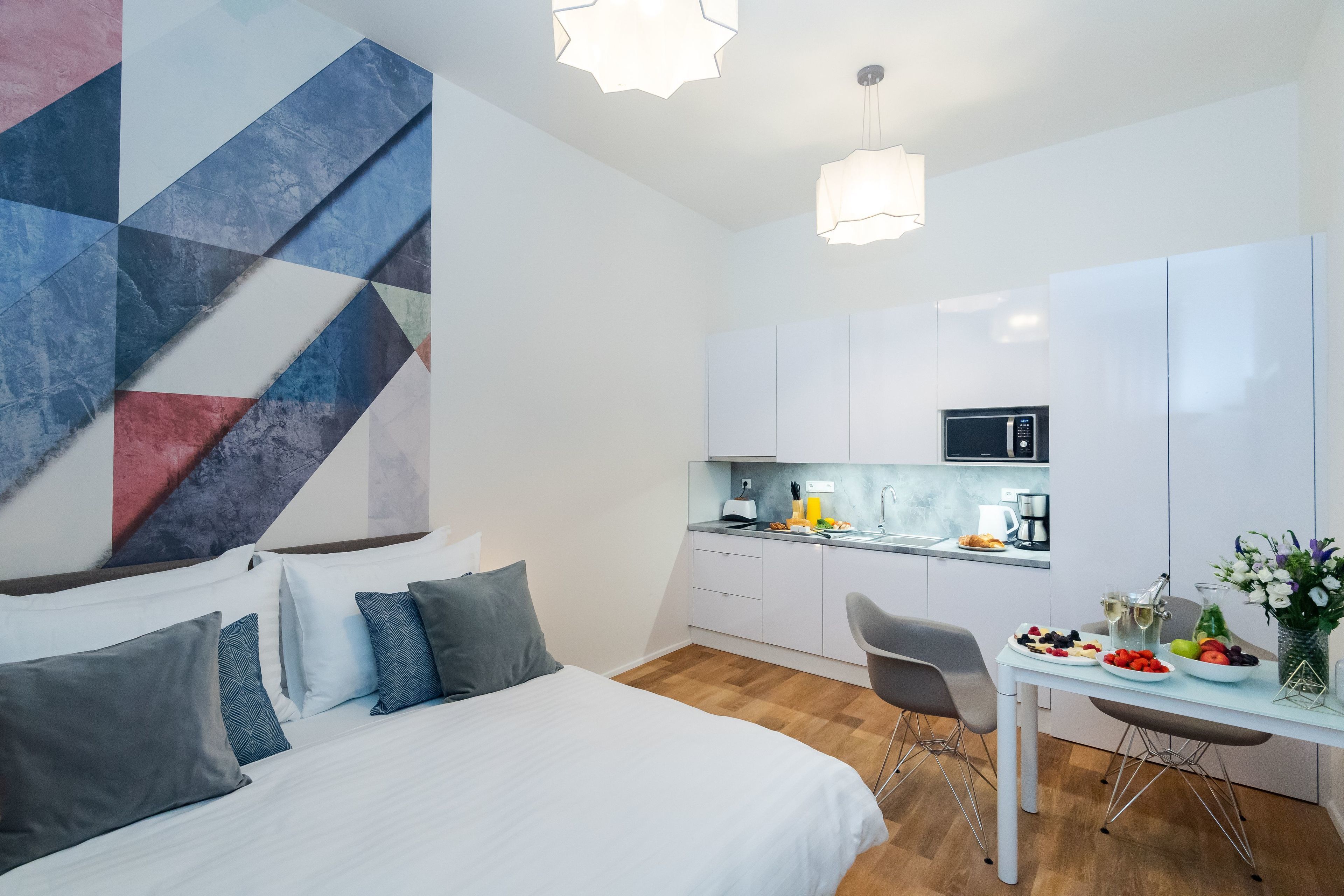Et moderne hotelværelse med seng, skrivebord og tekøkken.
