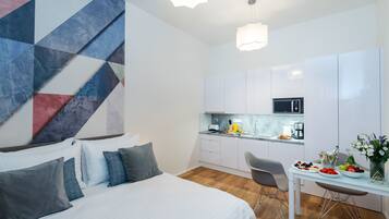 Et moderne hotelværelse med seng, skrivebord og tekøkken.