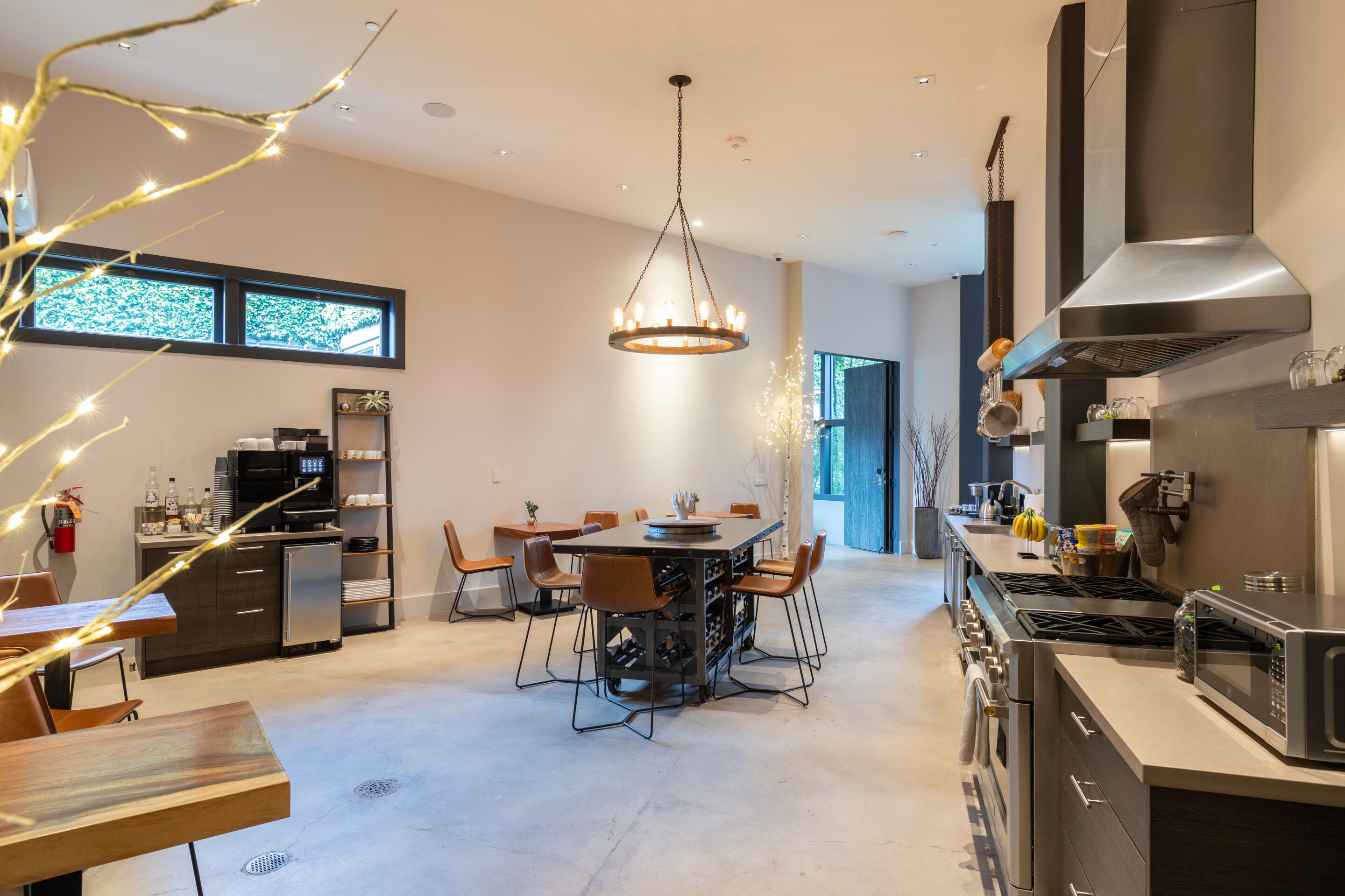 Una cocina moderna con comedor, electrodomésticos de acero inoxidable y una araña.