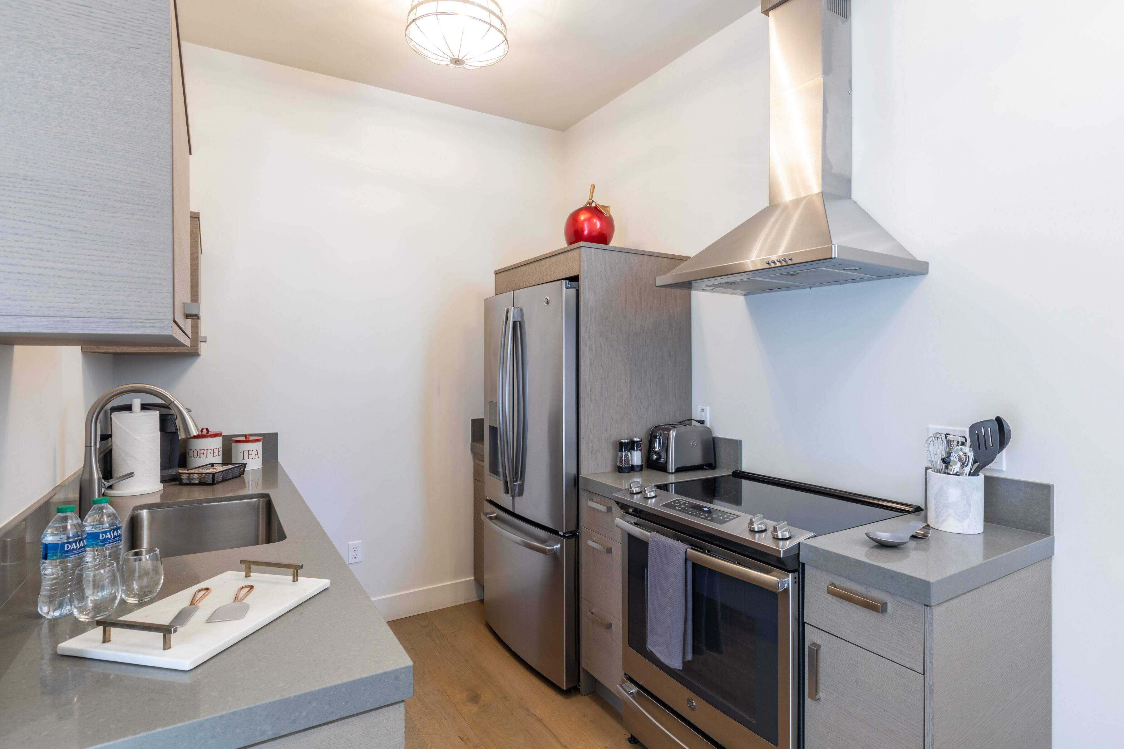 A modern kitchen with stainless steel appliances, a built-in oven, and a range hood.