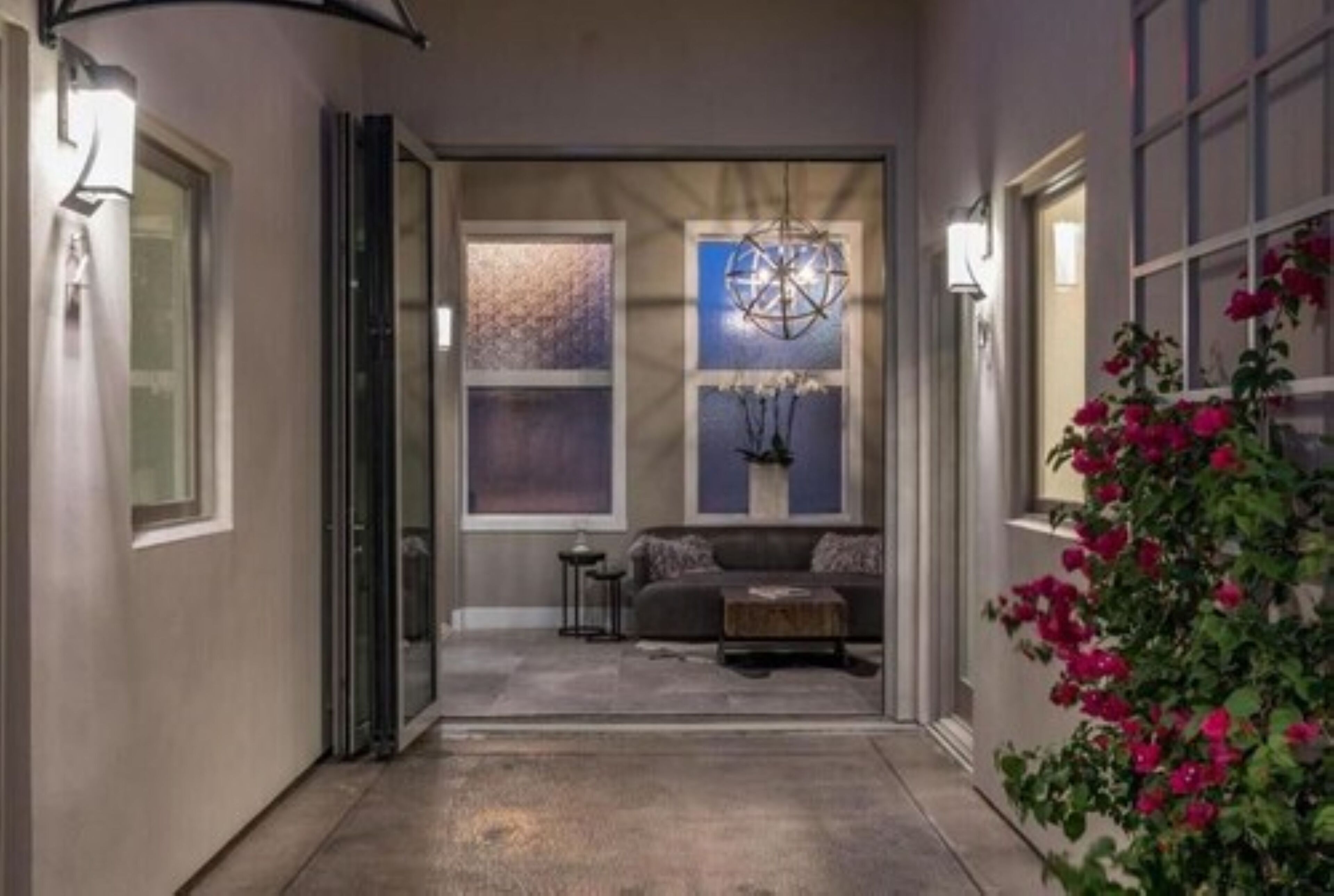 A hallway leading to a living area with a sofa, a coffee table, and decorative items.