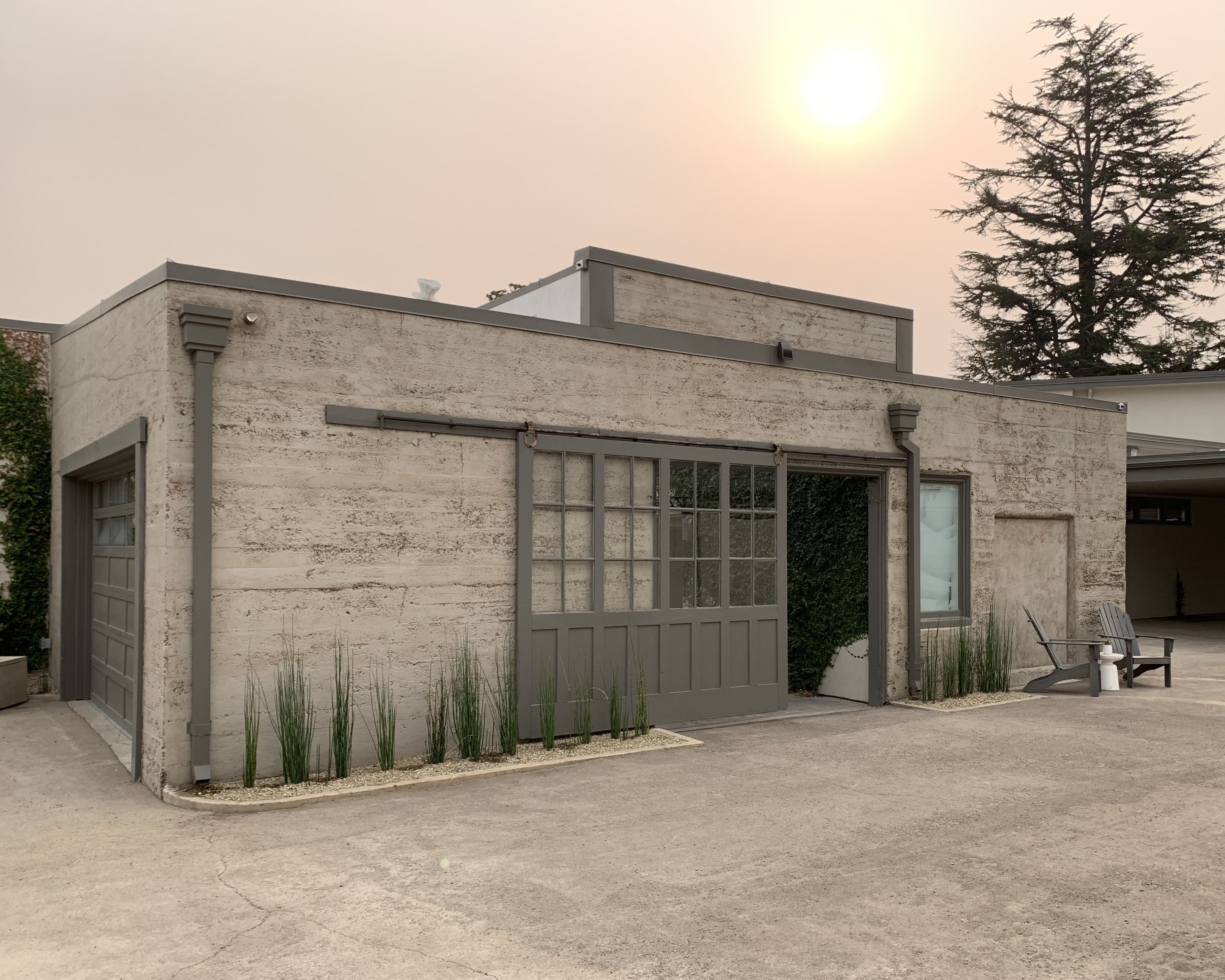 A small, single-story building with a garage door and a large window.
