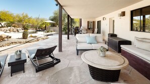 Un patio al aire libre con piscina, sillas de descanso, un sofá y una zona de comedor.