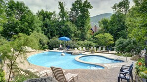 A swimming pool with lounge chairs and a blue umbrella. - Cozy condo - Walk to village/mountain - Monthly rates (Mont-Tremblant)
