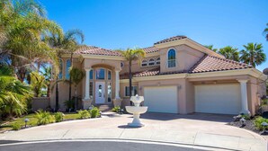 A two-story house with a tiled roof, a front entrance with a door, and a garage.