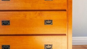 Een houten dressoir met meerdere lades en metalen handgrepen.