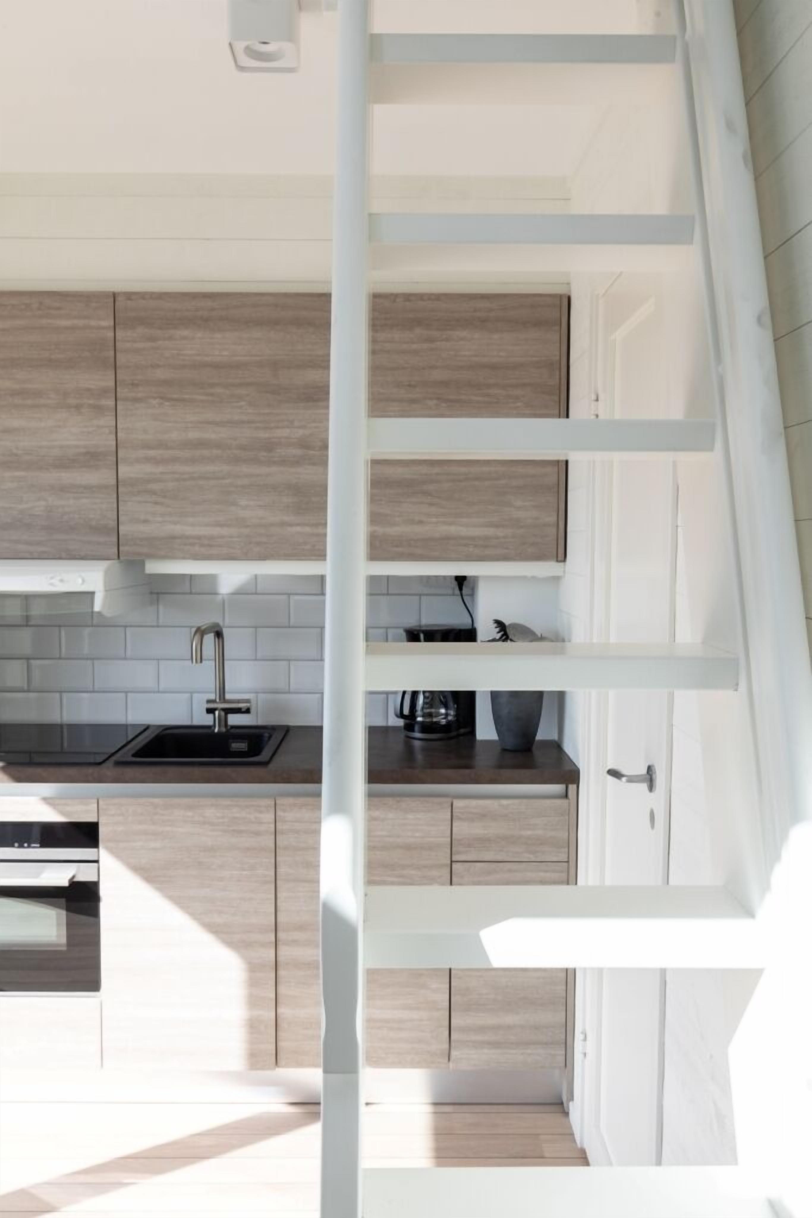 A modern kitchen with a built-in stove, a sink, and wooden cabinets.