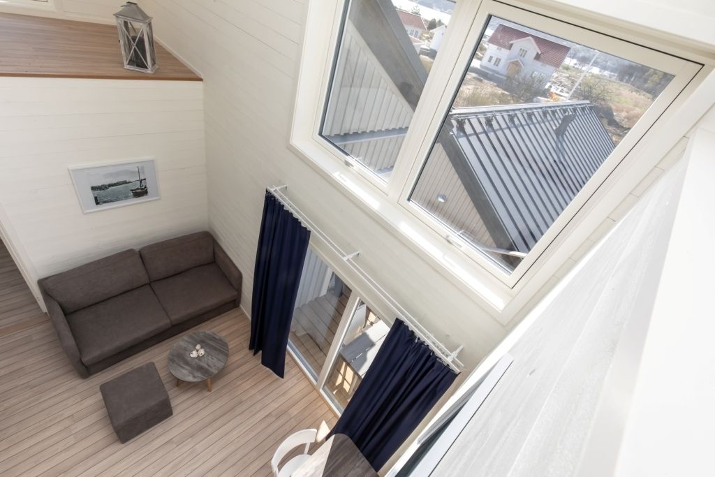 Un balcon avec un canapé, une petite table ronde et une vue sur le quartier.