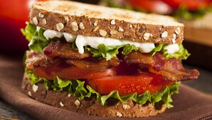 Un sándwich de lechuga, tomate y tocino sobre una rebanada de pan integral.
