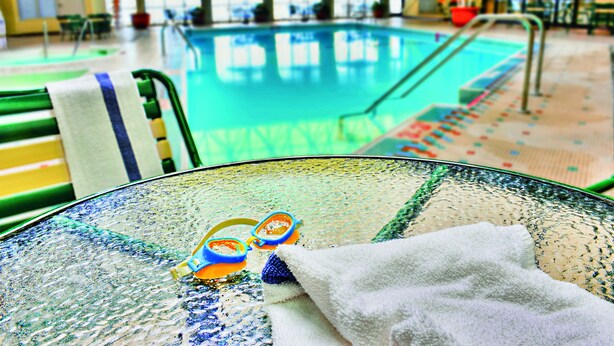 Una mesa de vidrio con una toalla y gafas de natación.