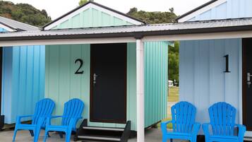 A row of two-room cabins numbered 1 and 2, each with a door and a small porch area.